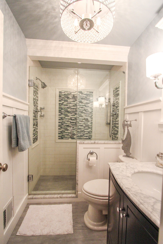 Inspiration for a small traditional 3/4 bathroom in Cincinnati with an undermount sink, raised-panel cabinets, dark wood cabinets, marble benchtops, a double shower, a two-piece toilet, white tile, subway tile, blue walls and travertine floors.