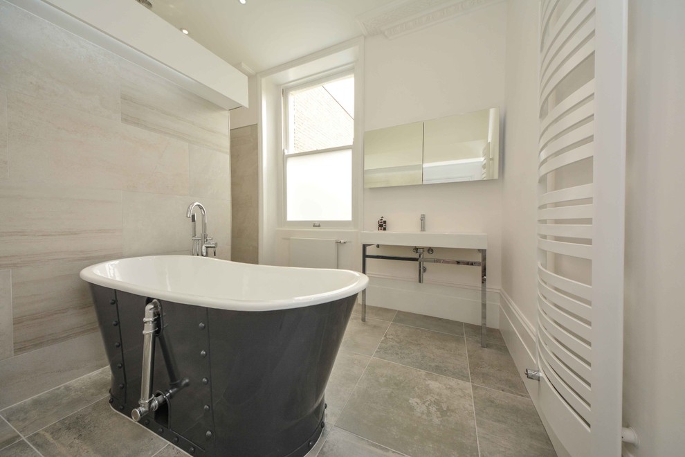 Photo of a large contemporary master bathroom in Kent with a trough sink, open cabinets, a freestanding tub, an open shower, a wall-mount toilet, gray tile, porcelain tile, white walls and ceramic floors.