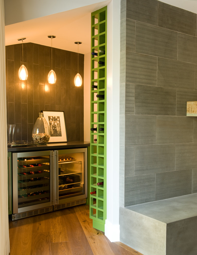 Photo of a mid-sized transitional single-wall wet bar in Los Angeles with no sink, glass-front cabinets, green cabinets, grey splashback and ceramic splashback.