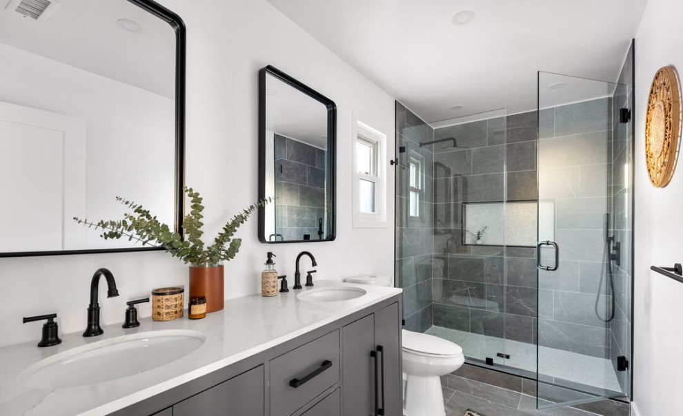 Alcove shower - contemporary concrete floor, gray floor and double-sink alcove shower idea in Los Angeles with flat-panel cabinets, gray cabinets, a one-piece toilet, white walls, an undermount sink, marble countertops, a hinged shower door, white countertops, a niche and a built-in vanity