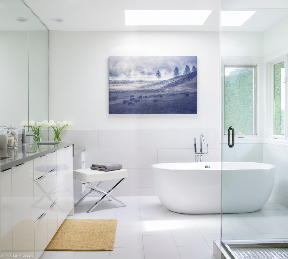 This is an example of a mid-sized contemporary master bathroom in Seattle with an undermount sink, flat-panel cabinets, white cabinets, a freestanding tub, a corner shower and white walls.