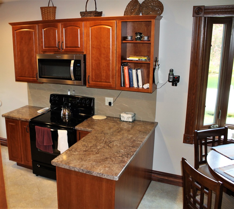 Example of a mid-sized mountain style l-shaped vinyl floor and beige floor eat-in kitchen design with a farmhouse sink, raised-panel cabinets, medium tone wood cabinets, laminate countertops, beige backsplash, cement tile backsplash, stainless steel appliances, a peninsula and beige countertops