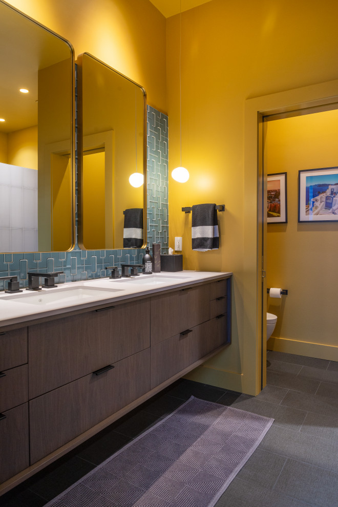 Idee per una stanza da bagno minimalista di medie dimensioni con ante lisce, ante in legno bruno, piastrelle verdi, piastrelle in ceramica, top nero, due lavabi e mobile bagno sospeso