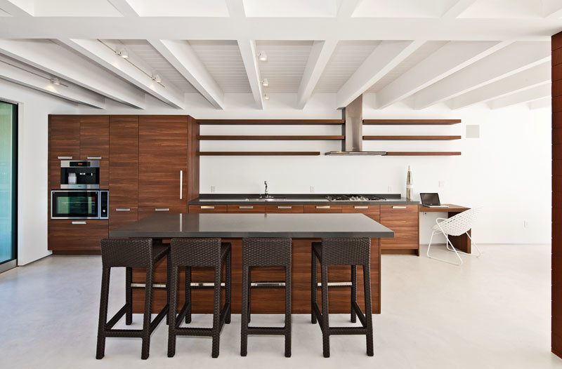 Photo of a large modern single-wall open plan kitchen in Los Angeles with a drop-in sink, flat-panel cabinets, dark wood cabinets, quartz benchtops, stainless steel appliances, cement tiles and with island.