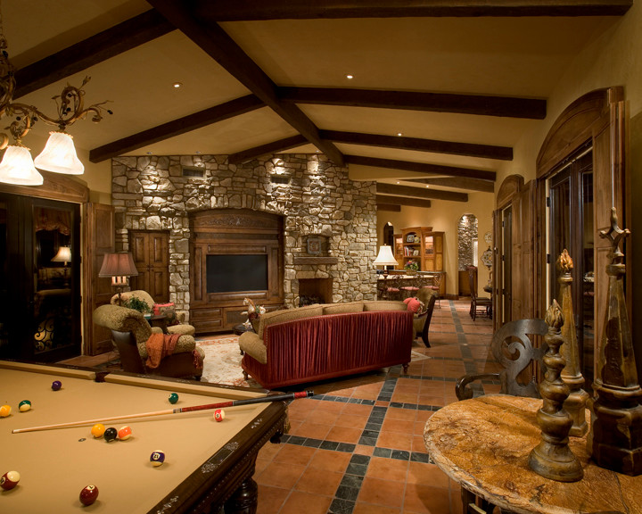 Inspiration for a large mediterranean enclosed family room in Phoenix with a game room, beige walls, ceramic floors, a built-in media wall and red floor.