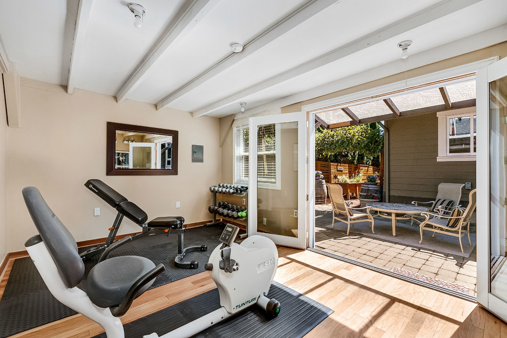Photo of a mid-sized transitional home weight room in Seattle with beige walls, light hardwood floors and beige floor.