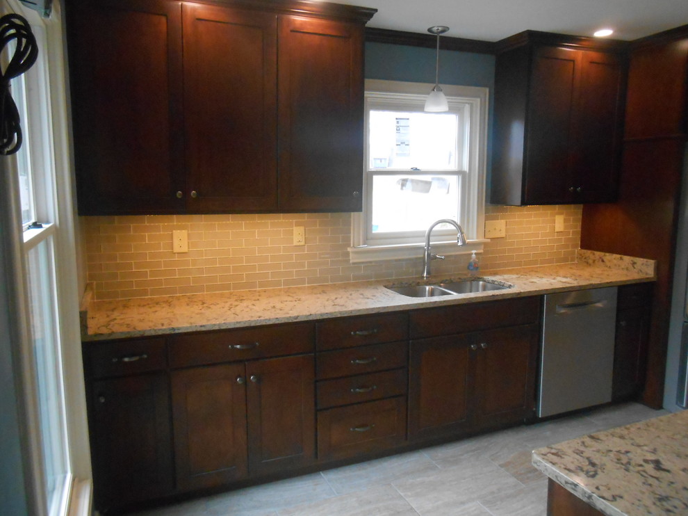 Mid-sized transitional galley porcelain tile eat-in kitchen photo with an undermount sink, shaker cabinets, dark wood cabinets, quartz countertops, beige backsplash, glass sheet backsplash, stainless steel appliances, blue walls and no island