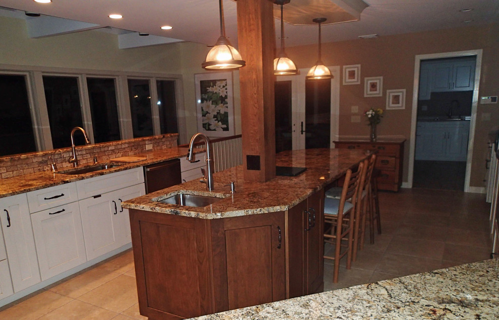 Inspiration for a large rustic ceramic tile eat-in kitchen remodel in Bridgeport with an undermount sink, shaker cabinets, granite countertops, beige backsplash, stone tile backsplash, stainless steel appliances and an island