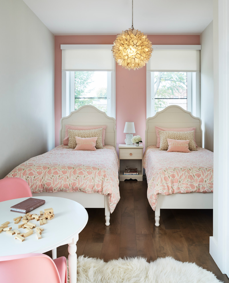 This is an example of a small transitional kids' bedroom for girls and kids 4-10 years old in New York with medium hardwood floors and multi-coloured walls.