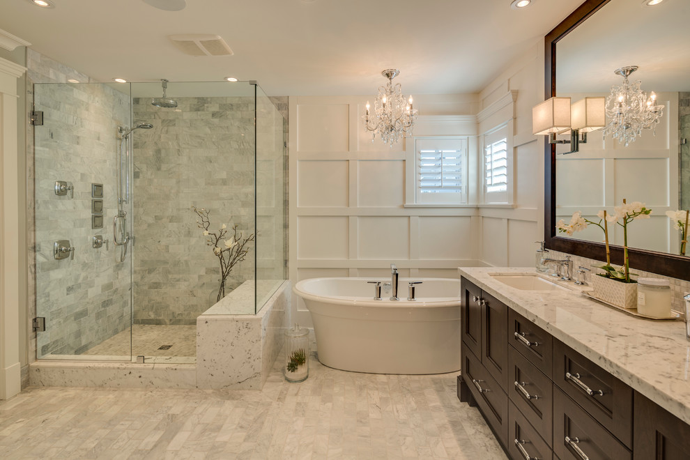 Mid-sized traditional master bathroom in Vancouver with an undermount sink, recessed-panel cabinets, dark wood cabinets, granite benchtops, a freestanding tub, a corner shower, gray tile, ceramic tile, white walls and porcelain floors.