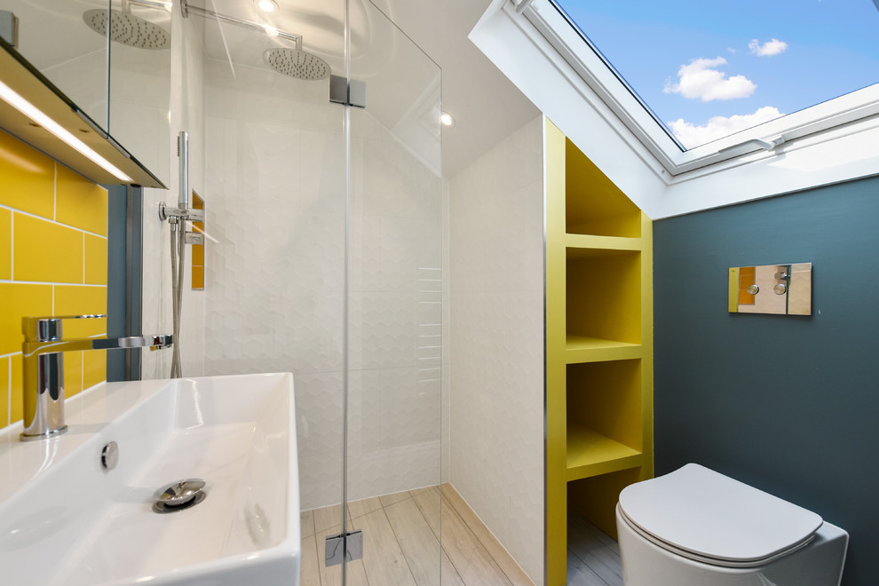 Inspiration for a small contemporary bathroom in London with a corner shower, yellow tile, subway tile, blue walls, a wall-mount sink, beige floor and a hinged shower door.