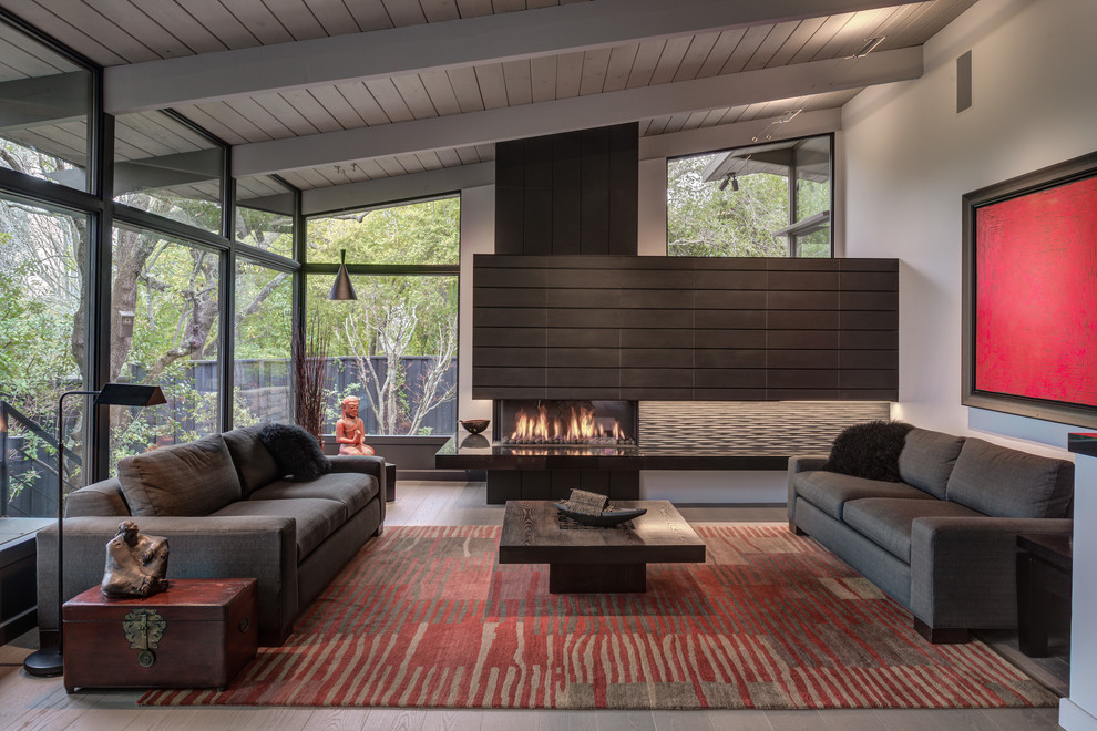 Inspiration for a large midcentury formal open concept living room in San Francisco with grey walls, light hardwood floors, a corner fireplace, a stone fireplace surround and grey floor.