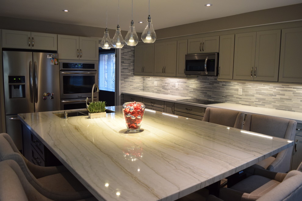 Mid-sized transitional l-shaped eat-in kitchen photo in Toronto with an undermount sink, shaker cabinets, gray cabinets, quartzite countertops, multicolored backsplash, subway tile backsplash, stainless steel appliances and an island