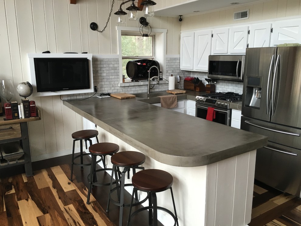 Inspiration for a country single-wall eat-in kitchen in Philadelphia with an undermount sink, shaker cabinets, white cabinets, concrete benchtops, stainless steel appliances, medium hardwood floors and with island.