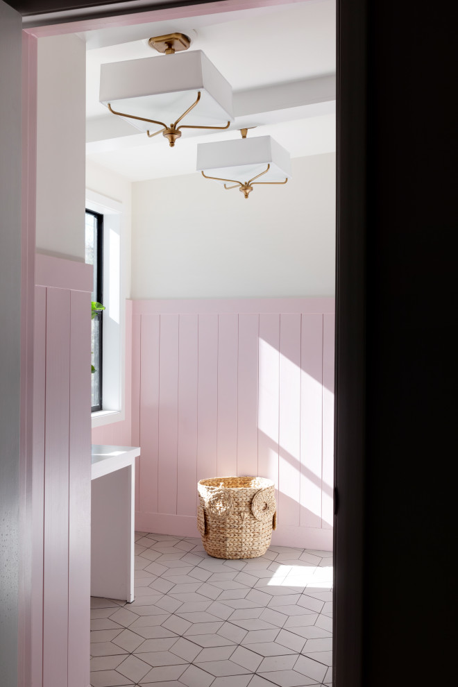 Laundry room in Kansas City with pink walls, porcelain floors, white floor and panelled walls.