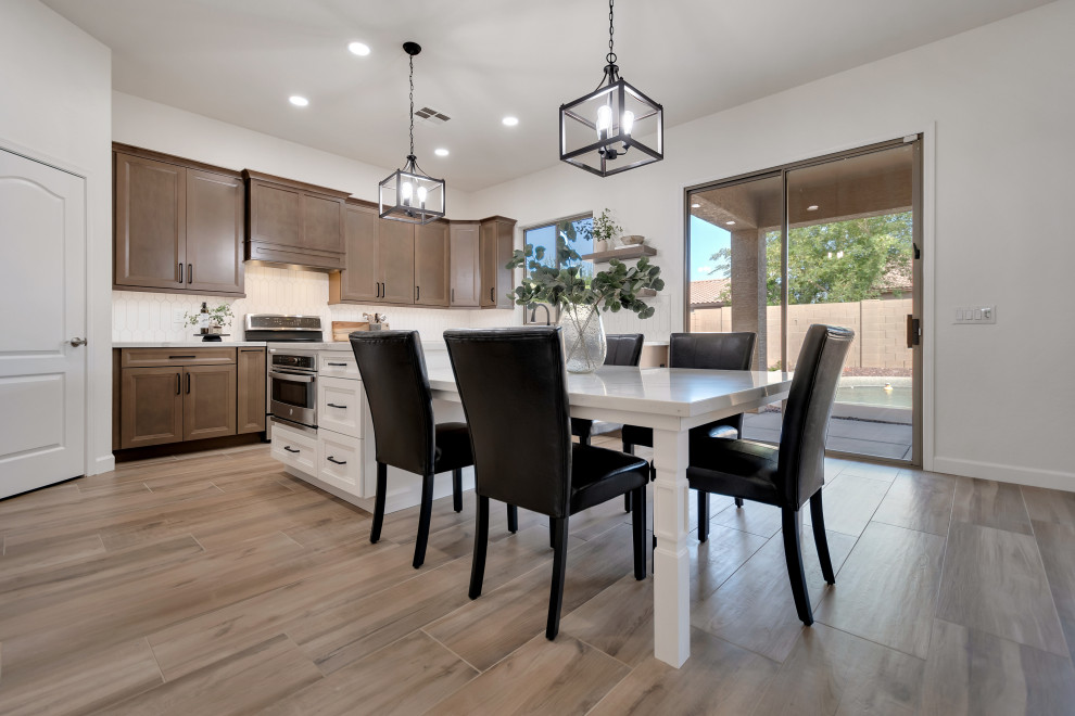 Example of a mid-sized transitional u-shaped ceramic tile and brown floor eat-in kitchen design in Phoenix with beaded inset cabinets, brown cabinets, quartzite countertops, white backsplash, ceramic backsplash, an island and white countertops
