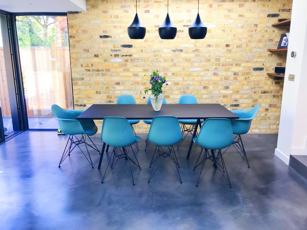 This is an example of a mid-sized modern dining room in London with white walls, concrete floors, no fireplace, a brick fireplace surround and grey floor.