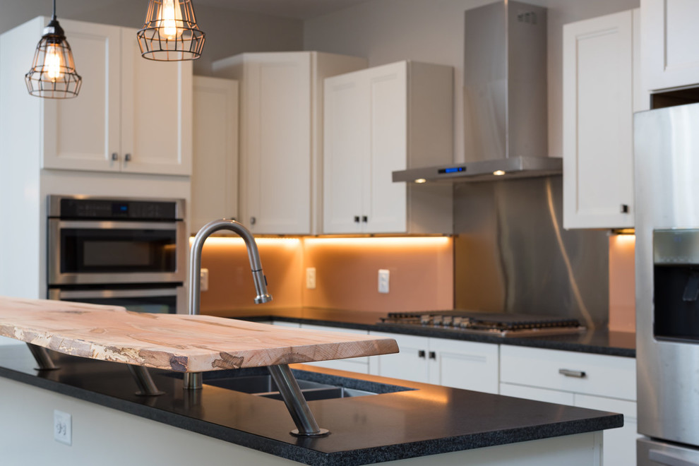 Eat-in kitchen - transitional u-shaped eat-in kitchen idea in DC Metro with a double-bowl sink, shaker cabinets, white cabinets, granite countertops, brown backsplash, glass sheet backsplash, stainless steel appliances, an island and black countertops