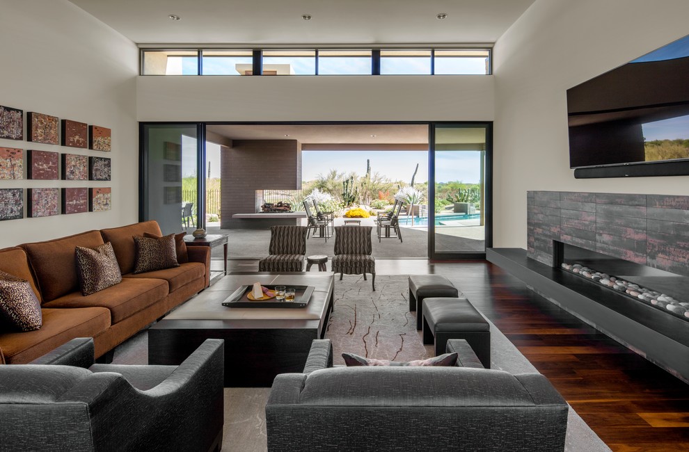 Example of a trendy open concept dark wood floor and brown floor living room design in Santa Barbara with white walls, a ribbon fireplace and a wall-mounted tv