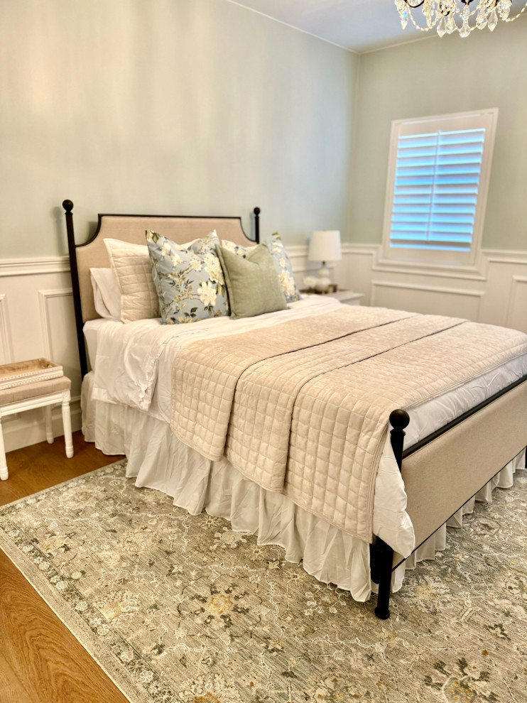 This is an example of a large traditional guest bedroom in Orange County with blue walls, laminate floors, brown floor and decorative wall panelling.