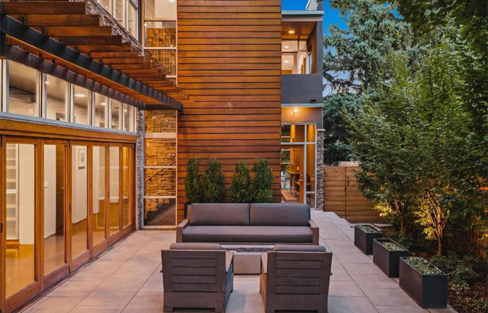 Design ideas for a medium sized modern side patio in Denver with a fire feature, concrete slabs and an awning.