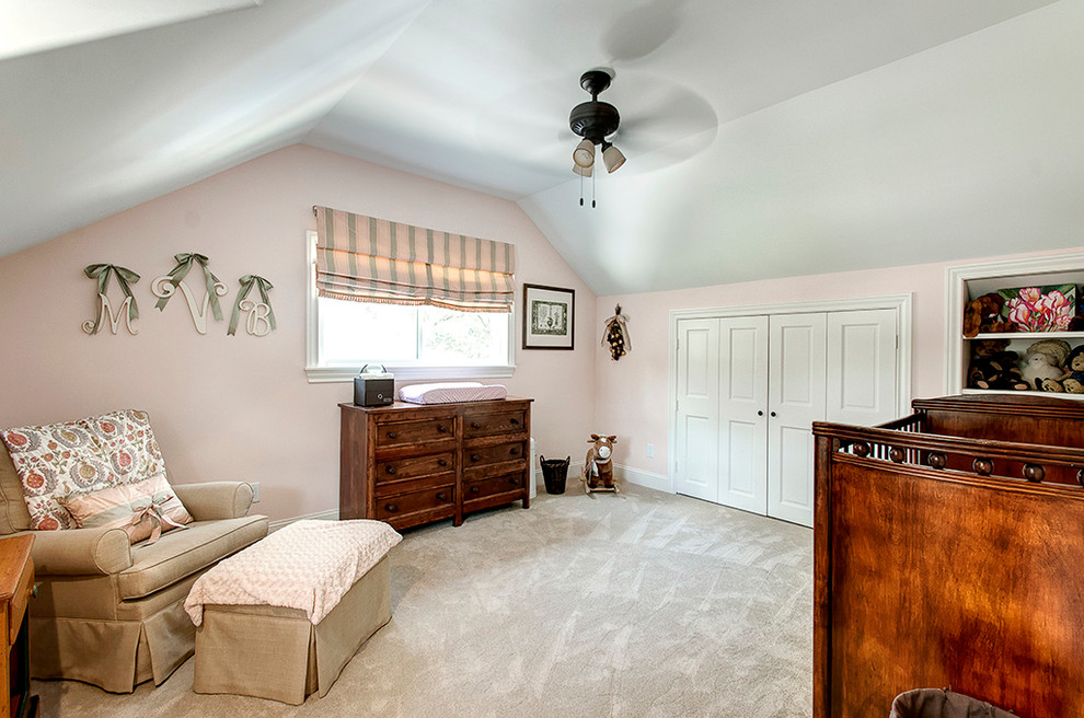 Photo of a mid-sized traditional nursery for girls in Houston with pink walls, carpet and beige floor.
