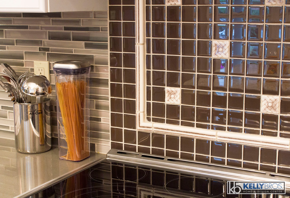 Inspiration for a mid-sized transitional u-shaped dark wood floor eat-in kitchen remodel in Cincinnati with an undermount sink, flat-panel cabinets, gray cabinets, quartz countertops, gray backsplash, glass tile backsplash, stainless steel appliances and an island