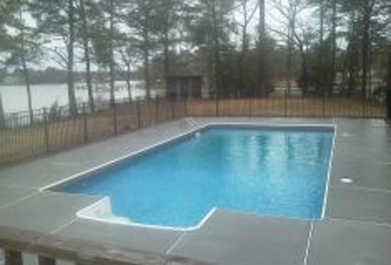 Example of a mid-sized backyard concrete paver and rectangular pool design