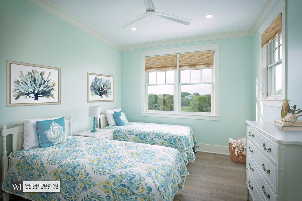 Mid-sized beach style guest bedroom in Tampa with blue walls, light hardwood floors, no fireplace and beige floor.
