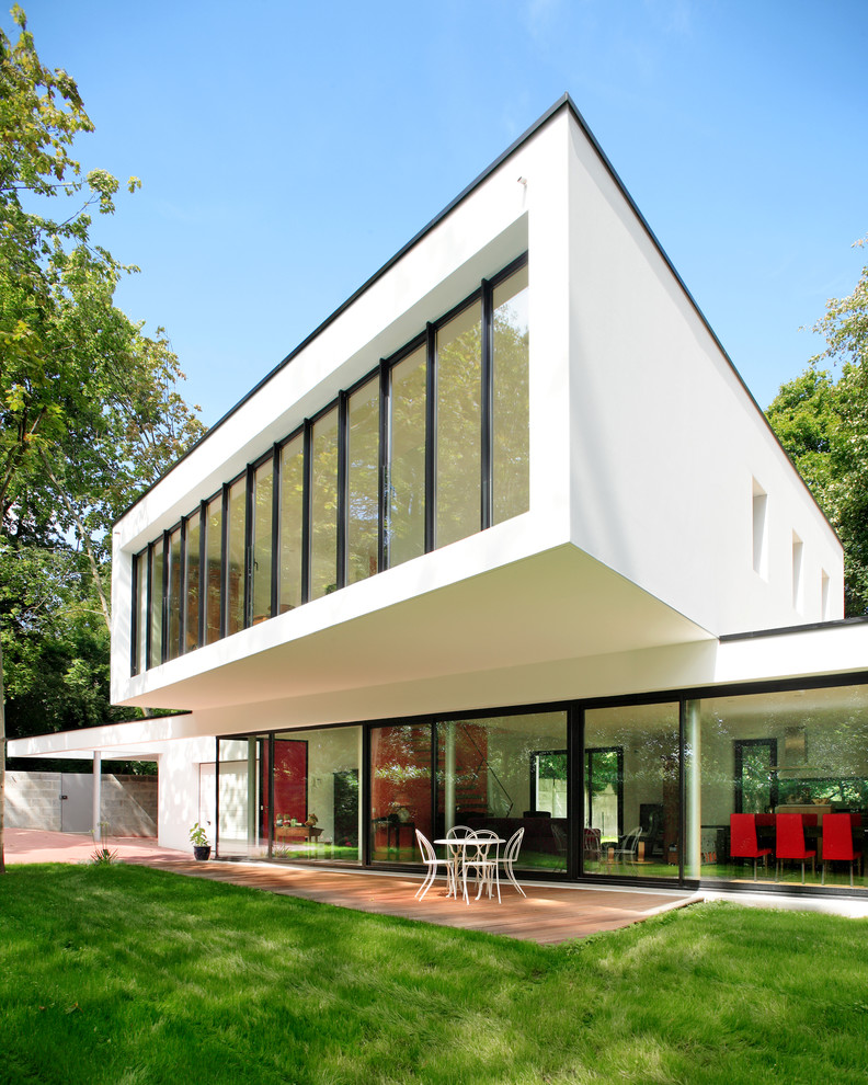 This is an example of a contemporary two-storey white house exterior in Nantes with a shed roof.
