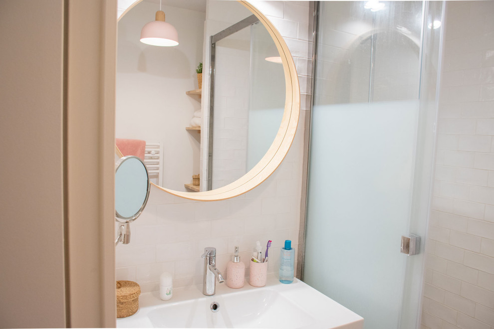 Exempel på ett mellanstort modernt en-suite badrum, med en vägghängd toalettstol, vit kakel, keramikplattor, vita väggar, cementgolv, ett konsol handfat, rosa golv och dusch med skjutdörr
