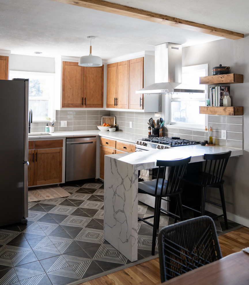 Example of a small transitional u-shaped ceramic tile and black floor eat-in kitchen design with an undermount sink, flat-panel cabinets, light wood cabinets, quartz countertops, gray backsplash, porcelain backsplash, stainless steel appliances, no island and white countertops