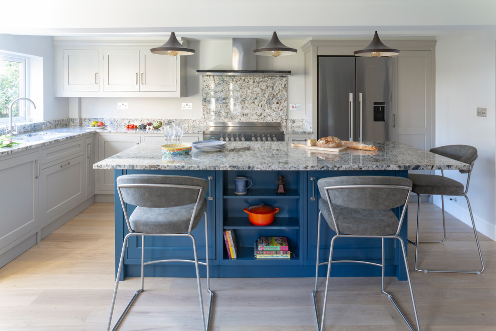 Photo of a mid-sized traditional l-shaped open plan kitchen in Wiltshire with an undermount sink, shaker cabinets, grey cabinets, granite benchtops, multi-coloured splashback, stainless steel appliances, light hardwood floors, with island and multi-coloured benchtop.