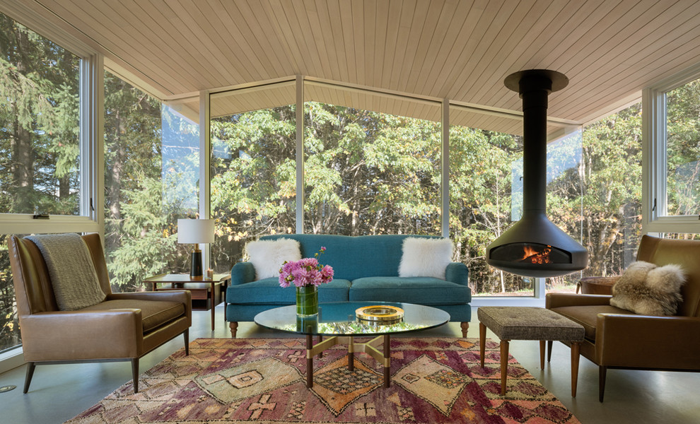 Photo of a country sunroom in Portland with concrete floors, a hanging fireplace and a standard ceiling.