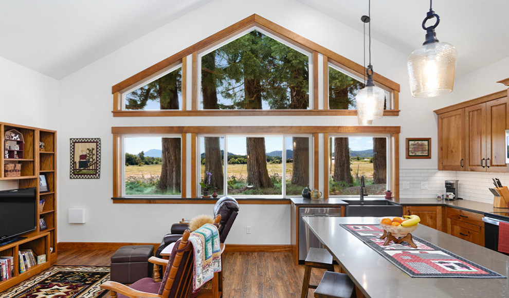 Kitchen - large rustic medium tone wood floor, brown floor and vaulted ceiling kitchen idea with a farmhouse sink, raised-panel cabinets, medium tone wood cabinets, concrete countertops, white backsplash, ceramic backsplash, stainless steel appliances, an island and gray countertops