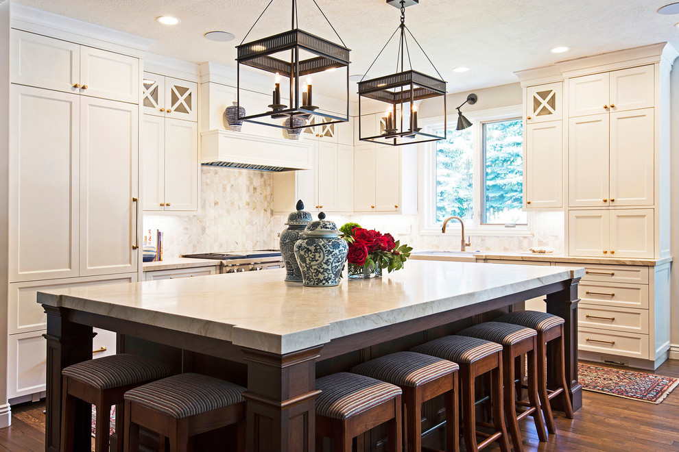 Inspiration for a traditional l-shaped kitchen in Salt Lake City with an undermount sink, shaker cabinets, beige cabinets, beige splashback, panelled appliances, dark hardwood floors, with island and brown floor.