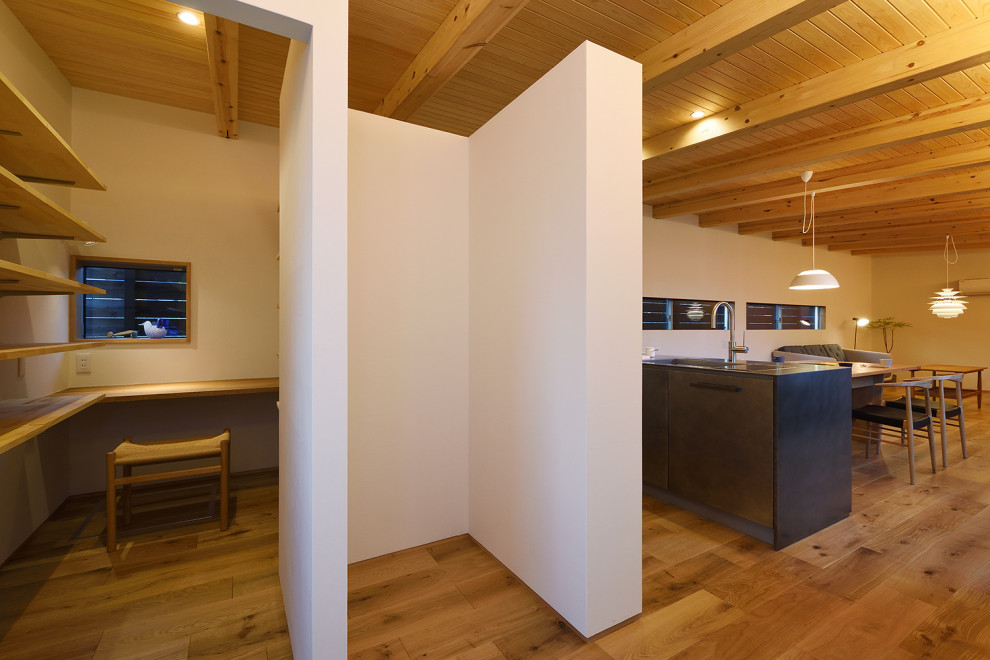 Diseño de despacho de tamaño medio sin chimenea con paredes blancas, suelo de madera en tonos medios, escritorio empotrado y madera
