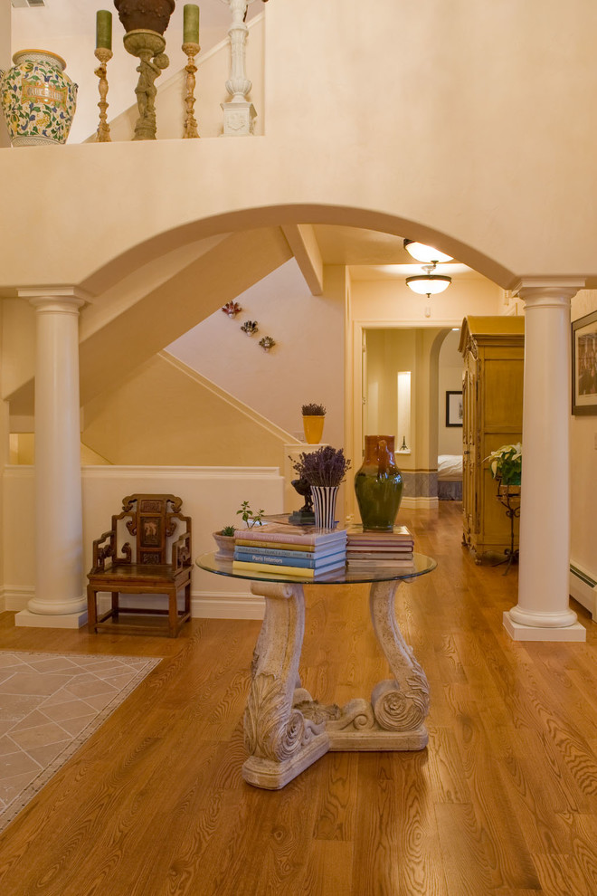 This is an example of a large traditional foyer in Denver with white walls and medium hardwood floors.