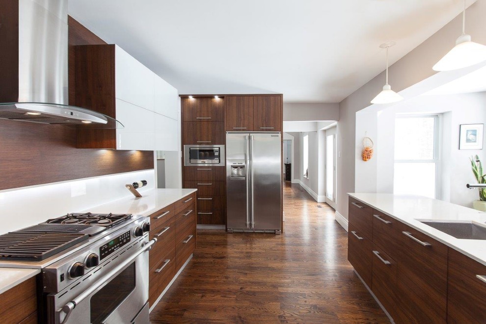 Design ideas for a large contemporary galley separate kitchen in Ottawa with an undermount sink, flat-panel cabinets, medium wood cabinets, quartz benchtops, white splashback, stainless steel appliances and medium hardwood floors.