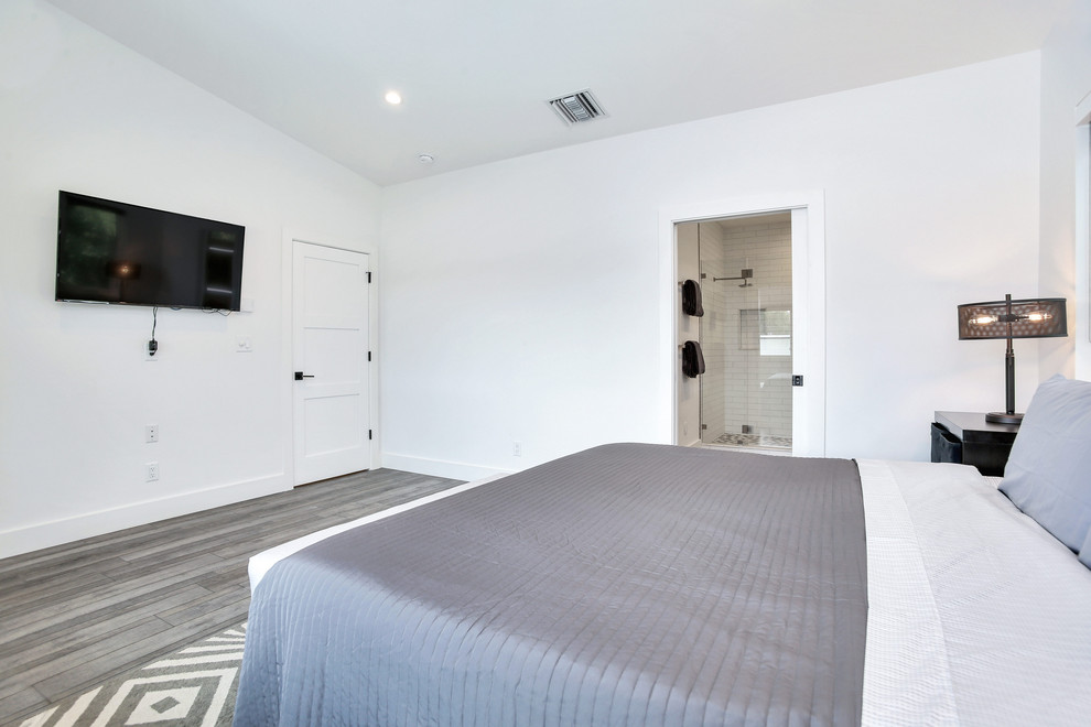 This is an example of a mid-sized industrial master bedroom in Tampa with white walls and grey floor.
