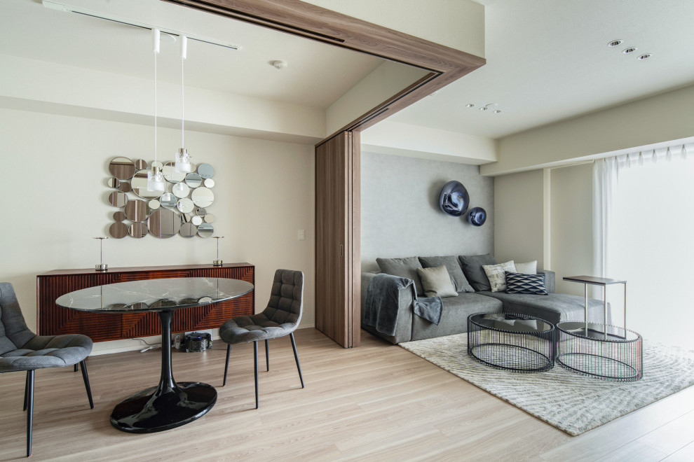 Immagine di un soggiorno minimalista di medie dimensioni e aperto con pareti grigie e TV autoportante
