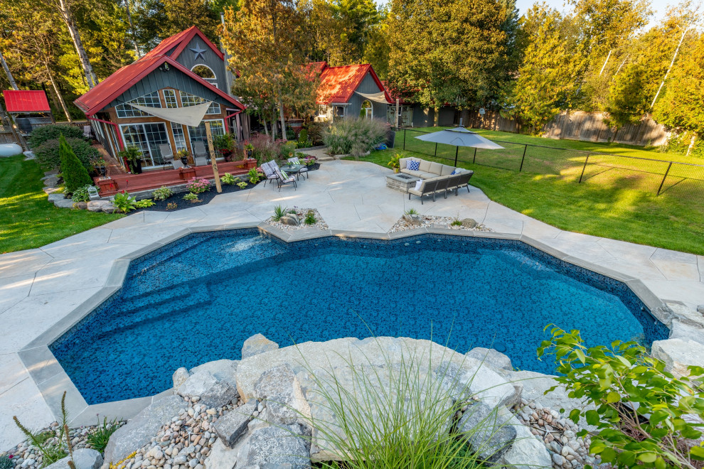 Inspiration for a mid-sized transitional backyard custom-shaped natural pool in Toronto with with a pool and stamped concrete.