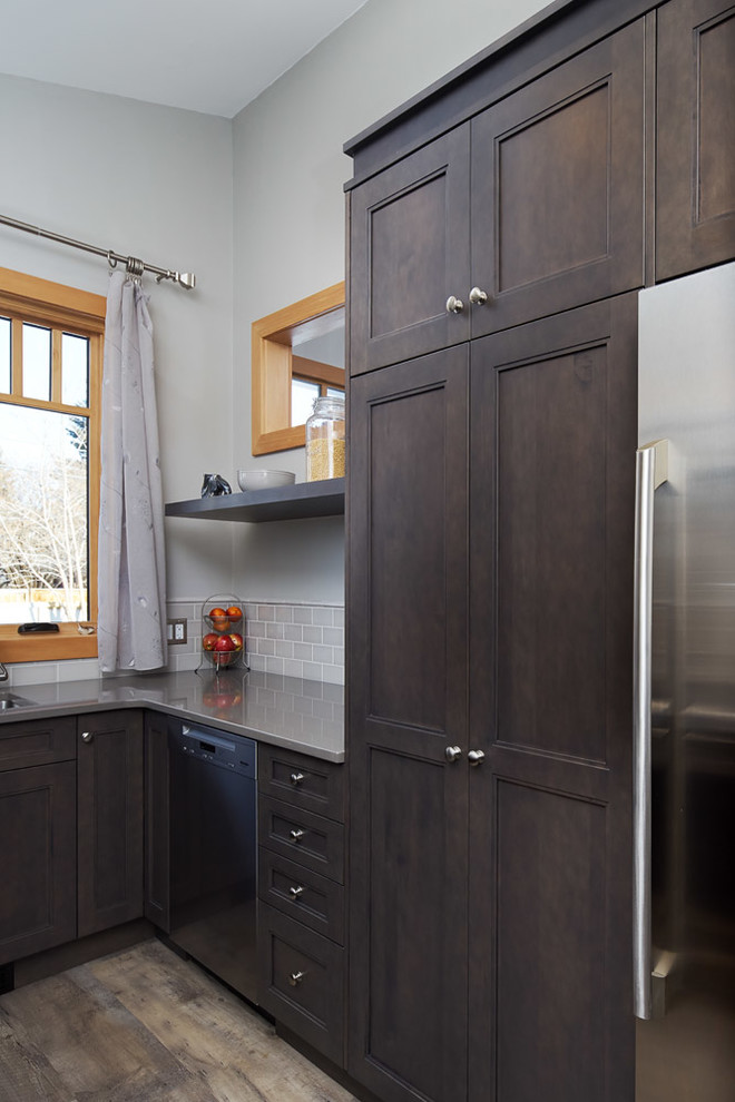Open concept kitchen - small transitional u-shaped medium tone wood floor and gray floor open concept kitchen idea in Calgary with an undermount sink, recessed-panel cabinets, dark wood cabinets, quartz countertops, gray backsplash, subway tile backsplash, stainless steel appliances and a peninsula