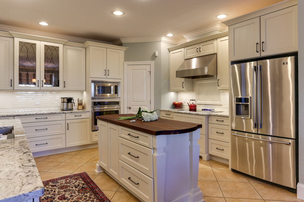 Mid-sized transitional u-shaped eat-in kitchen in Raleigh with a single-bowl sink, recessed-panel cabinets, white cabinets, granite benchtops, white splashback, ceramic splashback, stainless steel appliances, ceramic floors and with island.