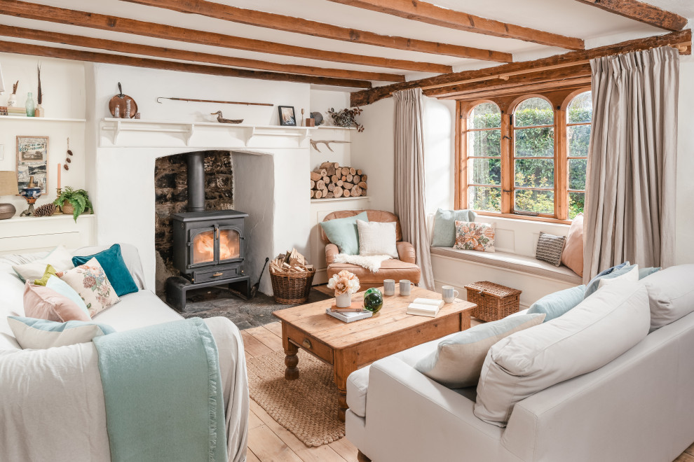 Inspiration for a mid-sized rustic light wood floor living room remodel in Cornwall with white walls and a standard fireplace