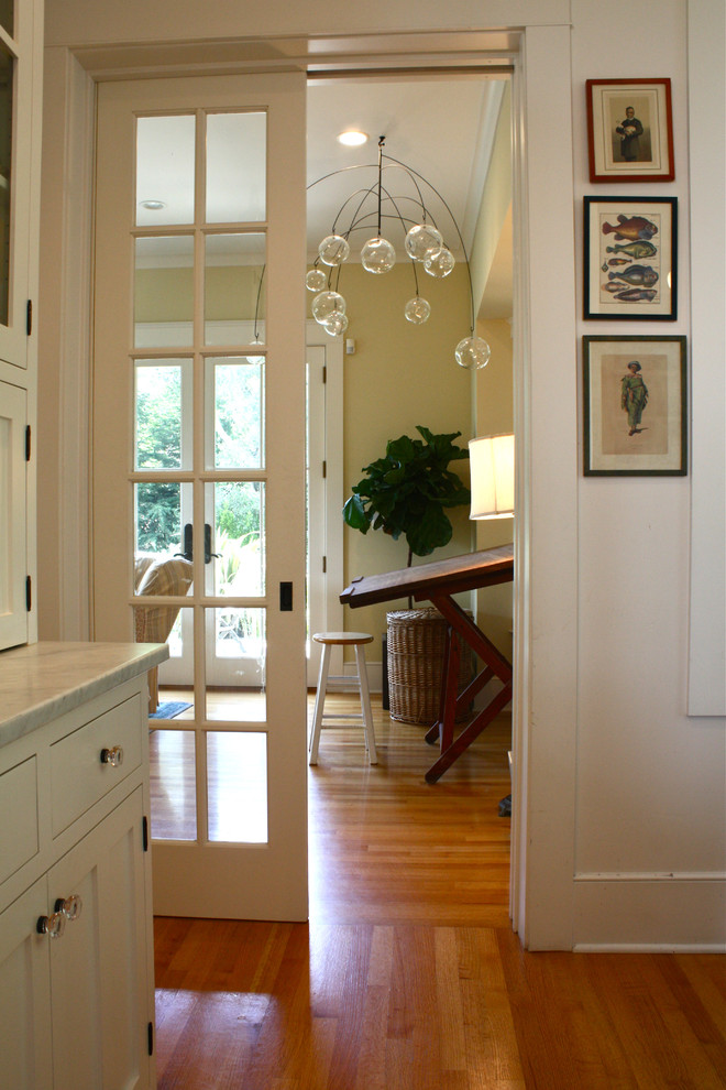 This is an example of a traditional hallway in San Francisco with beige walls, medium hardwood floors and orange floor.