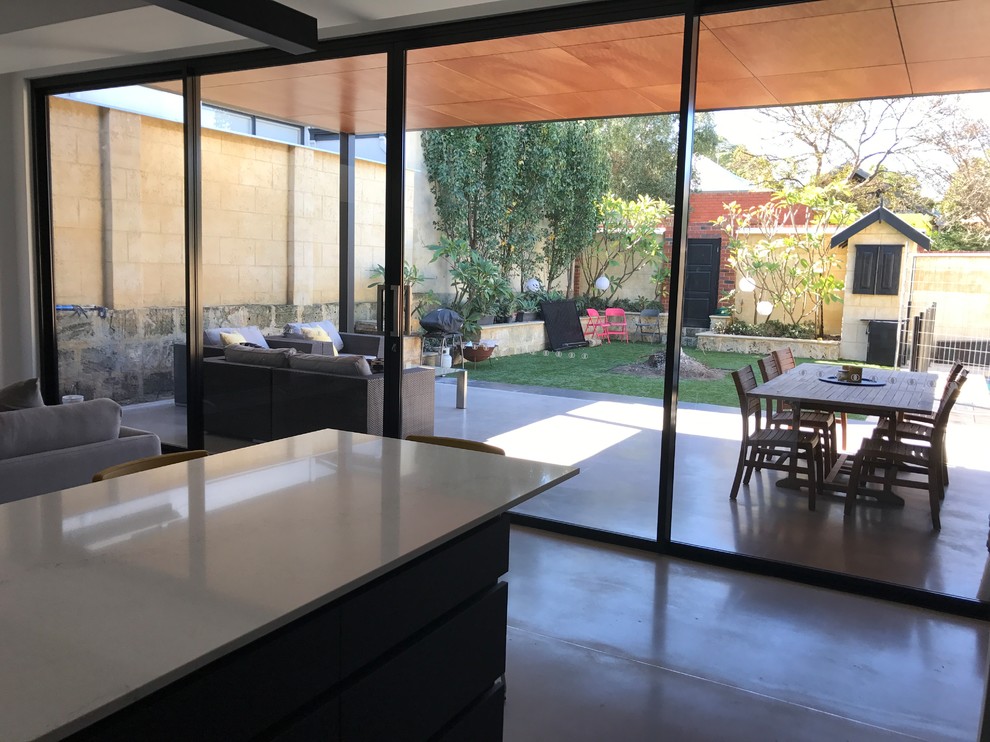 This is an example of a modern backyard patio in Perth with a roof extension.