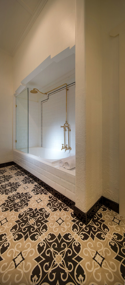 Inspiration for a mid-sized traditional 3/4 bathroom in Melbourne with white cabinets, a drop-in tub, a shower/bathtub combo, a two-piece toilet, black and white tile, ceramic tile, white walls, porcelain floors and a pedestal sink.