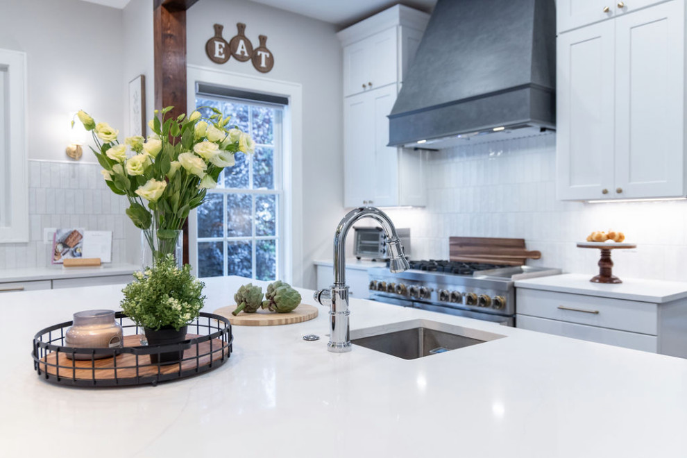 Inspiration for a large transitional u-shaped medium tone wood floor kitchen remodel in DC Metro with a single-bowl sink, flat-panel cabinets, quartz countertops, white backsplash, porcelain backsplash, stainless steel appliances, an island and white countertops