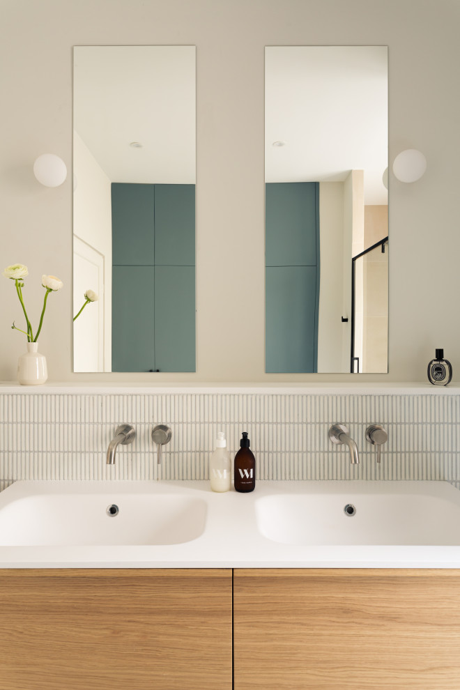 Idéer för ett stort minimalistiskt vit en-suite badrum, med luckor med profilerade fronter, skåp i ljust trä, en dubbeldusch, en toalettstol med separat cisternkåpa, vit kakel, mosaik, blå väggar, betonggolv, ett undermonterad handfat, bänkskiva i akrylsten, grått golv och dusch med gångjärnsdörr